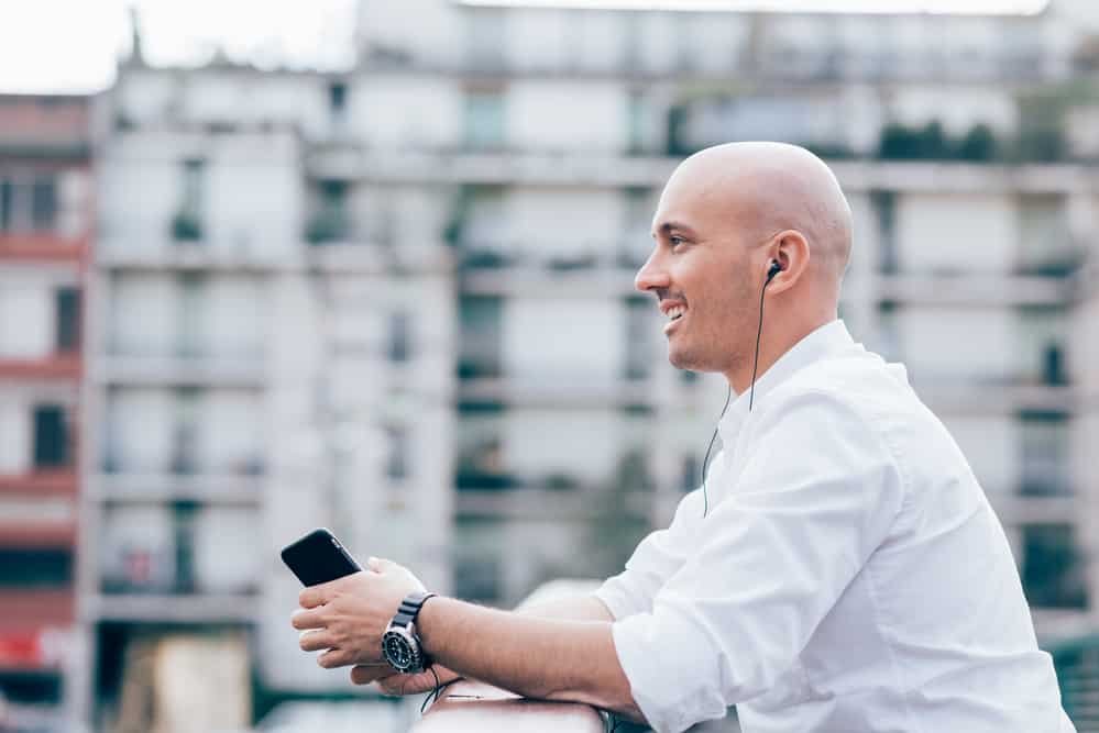 young bald man listening to music