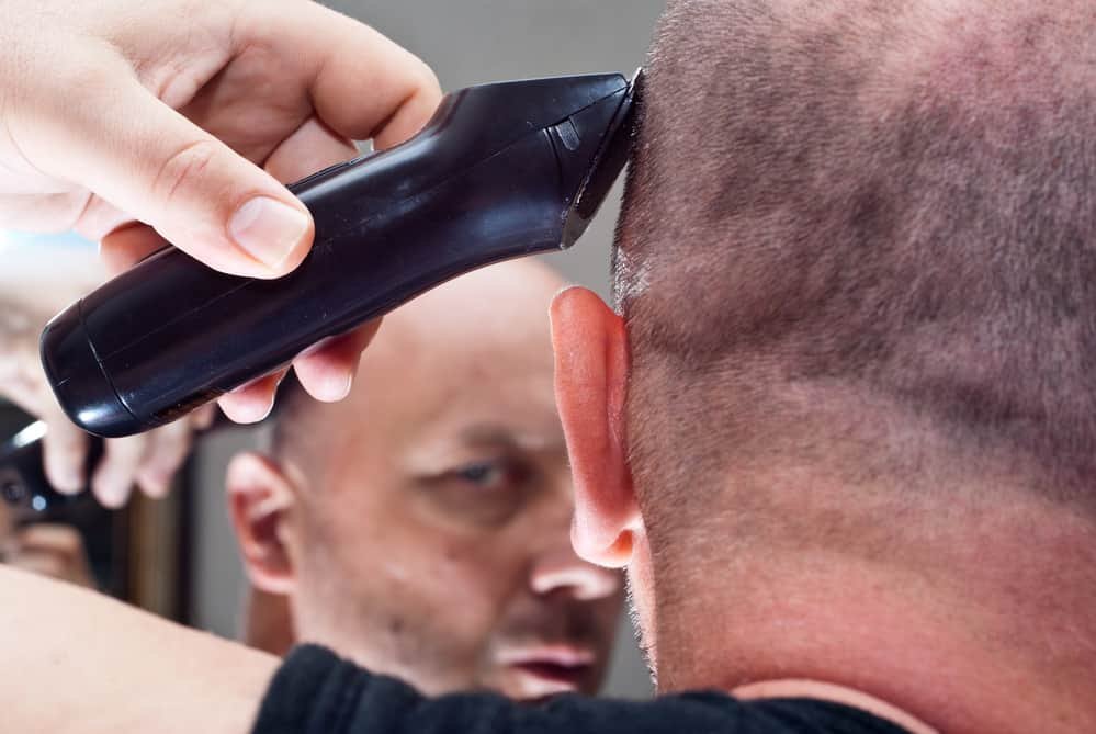 Man in the mirror cuts her hair